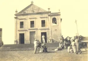 Capela vista de frente, com pessoas no largo