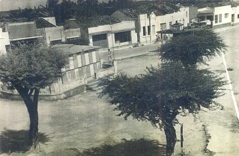 Praça antiga com árvores e construções ao redor