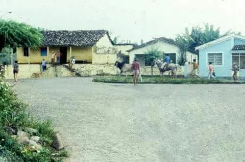 Casas antigas e moradores diante de uma rua aberta