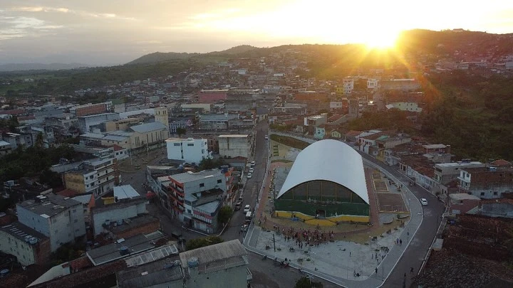 Vista aérea de João Alfredo ao pôr do sol, com ruas, casas e uma praça coberta